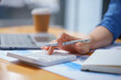 © Songsak C - Close-up portrait of businesswoman accountant using calculator and laptop for matching financial data saving in office room, Business financial, tax, accounting concept