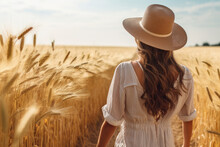 Back View Of A Woman Wearing Hat Standing In The Ripe Wheat Field