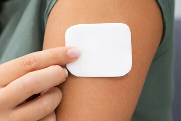 woman applying patch on her arm