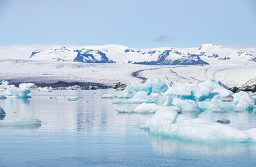 Wall Mural - Ice floes in a glacial lake in Iceland with vulcano mountains in the background, the climate crisis in northern Europe, glacial melting, beautiful landsacpe