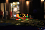 Fototapeta Miasto - taxi lantern on the roof of the car at night