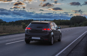 Poster - Crossover driving on a country road at sunset