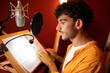 © ADDICTIVE STOCK - Cheerful young ethnic man sitting and recording podcast with microphone in studio