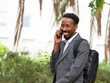 © ADDICTIVE STOCK - Smiling black businessman talking on smartphone