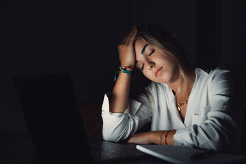 Overwhelmed young caucasian student touching head, suffering from blurry eyesight, massaging nose bridge relieving pain, feeling exhausted working late in evening on computer in office..