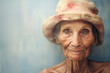© ADDICTIVE STOCK - Generative AI illustration portrait of a positive elderly woman with grey hair wearing a hat looking at the camera against a blurred grey background