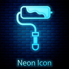 Poster - Glowing neon Paint roller brush icon isolated on brick wall background. Vector