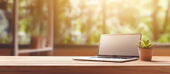 Poster - Blurred office background with a wooden desk laptop wireless mouse graphics tablet and notebook
