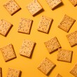 © Simona - Tasty crispy crackers on a yellow background. Generative AI.