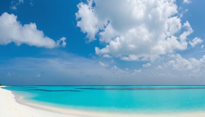 Wall Mural - Sandy beach with white sand and rolling calm wave of turquoise ocean on sunny day, white clouds in blue sky background