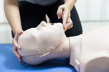 Wall Mural - Demonstrating CPR (Cardiopulmonary resuscitation) training medical procedure on CPR doll in the class.Doctor and nurse students are learning how to rescue the patient.First aid for safe life concept.