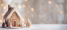 Glazed Gingerbread House With Holiday Lights In Background. Christmas Decoration. Tradicional Homemade Sweets. Banner With Copy Space