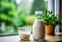 Glass Of Milk On A Wooden Table By Window In Kitchen