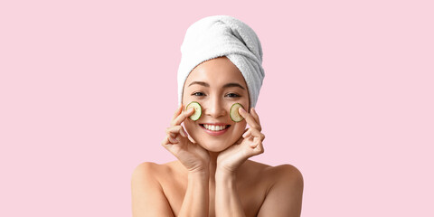 Poster - Beautiful Asian woman with cucumber slices on pink background