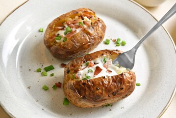 Baked potato with bacon, sour cream and green onion