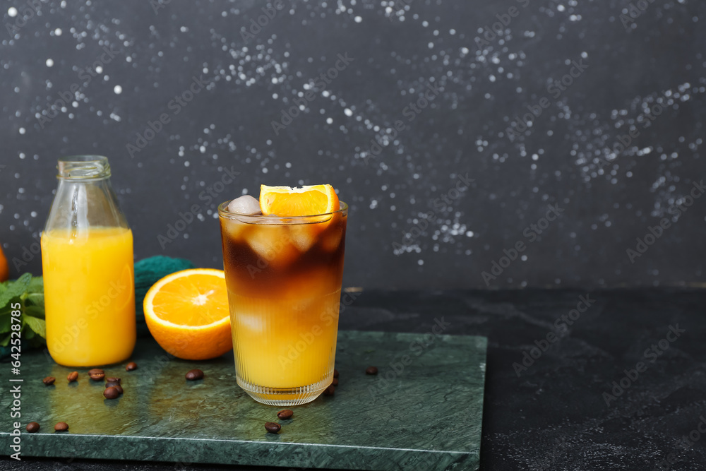 Glass of tasty orange espresso on table