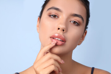 Poster - Young woman with beautiful lips on blue background, closeup