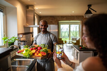 Interracial Middle Aged Couple Taking A Photo With A Smart Phone While Preparing A Healthy Dish With Fresh Fruits And Vegetables At Home Representing A Healthy Lifestyle And Diet