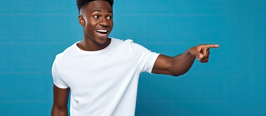 Wall Mural - Annoyed young African American man posing with copy space pointing and shouting