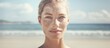Composite digital image of a Caucasian woman on the beach promoting skin pigmentation awareness and treatment