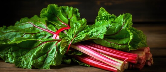 Leinwandbilder - Freshly harvested red rhubarb bundle on wooden background close up
