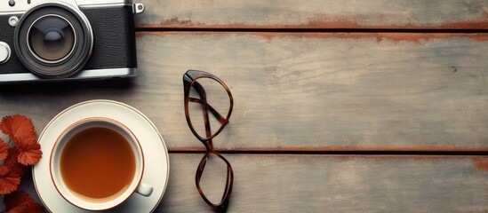 Poster - Retro camera coffee cup notepad and glasses arranged on a wooden table from a top viewpoint