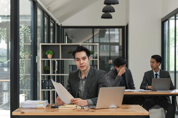 Wall Mural - Smiling male business sitting in office and working on laptop