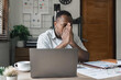 Unhappy hopeless African American man holding head in hands, overwhelmed tired businessman sitting at work desk with laptop, feeling exhausted, financial problem, loss money or bankruptcy