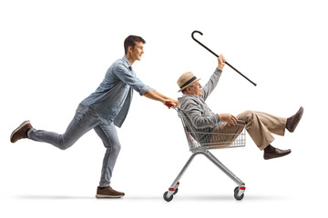 Wall Mural - Grandson pushing his grandfather inside a shopping cart