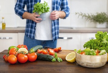 Poster - Various fresh vegetables ingredients for cooking healthy food on a wooden table in modern home kitchen