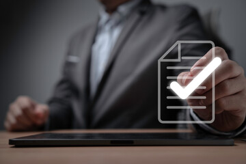 Fototapete - Businessman using electronic pen tick correct sign mark on virtual document for online approve  paperless and quality assurance concept.