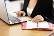 © Francesco - Businesswoman in working environment typing on a laptop and reading agenda