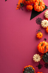 Wall Mural - Elevate the carnival excitement with this Halloween layout. Vertical top view shot featuring festive garland and party accessories amidst pumpkins, spiders, centipede and cobweb on a crimson canvas