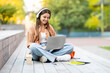 © Prostock-studio - Young woman with long hair student using notebook on street