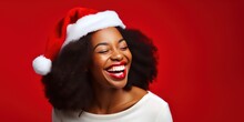 African American Young Woman In Santa Hat Over Red Background. Happy Laughing Young Woman.