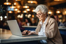 Elderly Old Woman Pensioner Grandmother In Glasses Behind A Computer Screen Works And Communicates