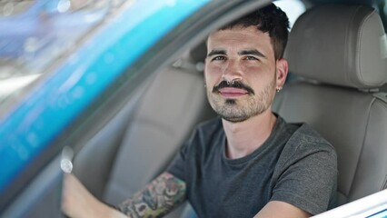 Wall Mural - Young hispanic man smiling confident driving car at street