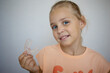 © evgeniia_1010 - transparent mouth guard made of silicone, for straightening teeth in children, in a girl's hand, in daylight. Hygiene, dental care, occlusion correction, new technologies