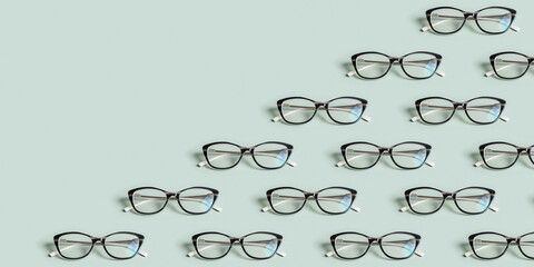 Wall Mural - Glasses for vision on a green background with copy space. Optical store, vision test, stylish glasses concept. Banner