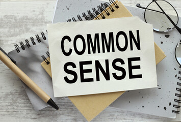 Common sense gray wooden background. gray notebook. text on the page