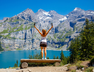 Wall Mural - Hiker woman enjoying Swiss lake and alps mountain