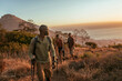 © Marko Geber - Young and diverse group of people and hikers hiking on a ridge overlooking the ocean and a beautiful sunset in South Africa