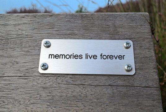 'Memories live forever' is written on a plaque on the back of a bench