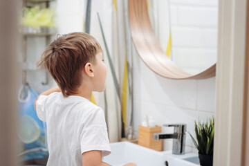 Wall Mural - cute 5 years old boy brushing teeth with bamboo tooth brush in bathroom. Image with selective focus