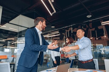 Wall Mural - colleagues are shaking their hands in modern office during teamwork. high quality photo
