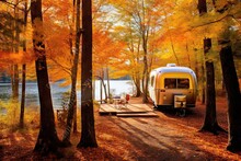 An Rv Parked On The Shore Of A Lake Surrounded By Autumn Foliage And Trees With Yellow Leaves In The Fore
