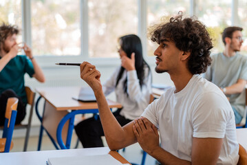 In the classroom group of college students are listening to a lecturer and are involved in the discussion.