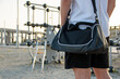 Mid section of a young man going to the outdoor sports center with his athletics bag. Copy space.