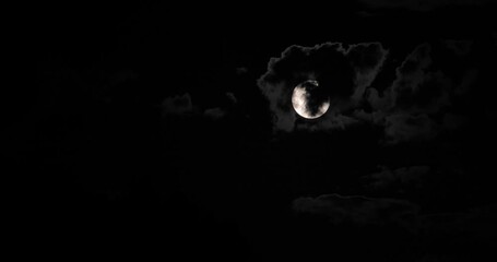 super moon behind clouds at night