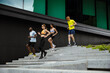 © Drobot Dean - Group of people running down the stairs while doing workout together outdoors